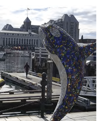 A glass orca greets visitors with the provincial capital buildings in the background.